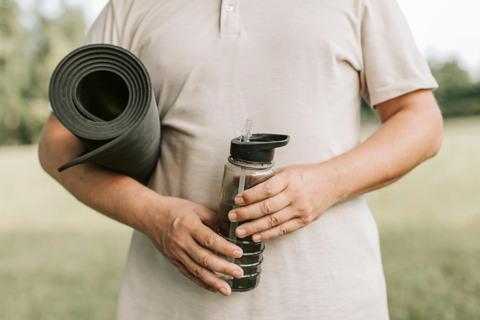 Neatly rolled yoga mat and a water bottle in a calm, prepared space.